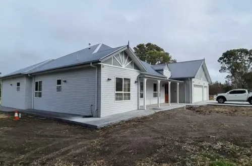 Completed weatherboard home with UPVC windows, side view